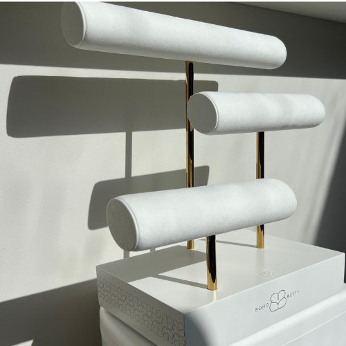 Boho Betty three-tier T-bar jewellery stand featuring white faux suede bars at varied heights with gold metal supports on a white branded base.