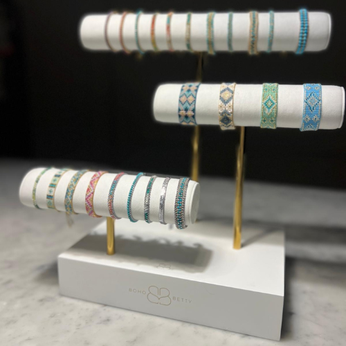 Boho Betty’s three-tier stand showcasing a variety of bracelets on soft white faux suede, ideal for boutique or retail displays.