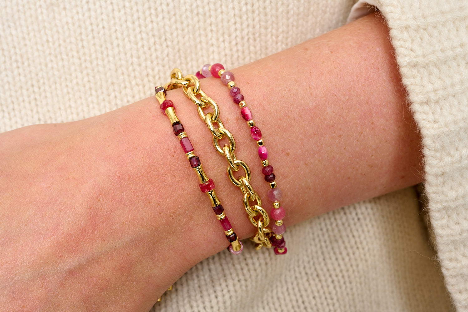 Chiara Gold & Garnet Bead Slider Bracelet styled in a boho bracelet stack with deep red gemstones and golden accents.