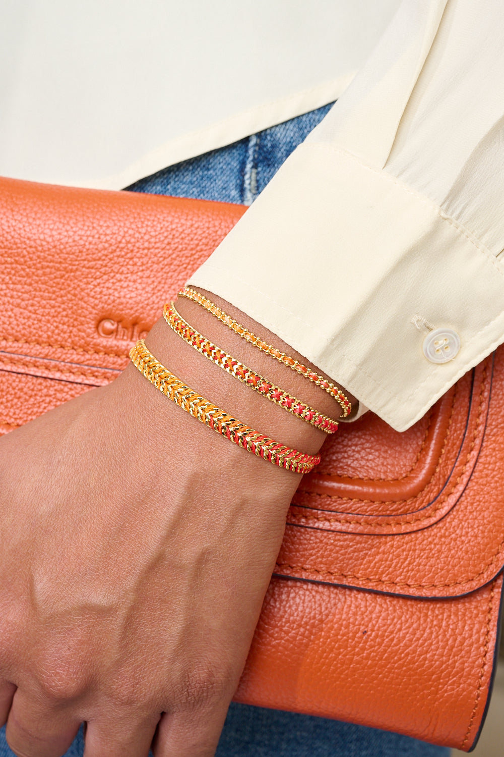 Iztac Gold Sunset Braided Friendship Bracelet styled on a wrist, glowing with warm red and gold threads, perfect for stacking, gifting, and sunset-soaked adventures.