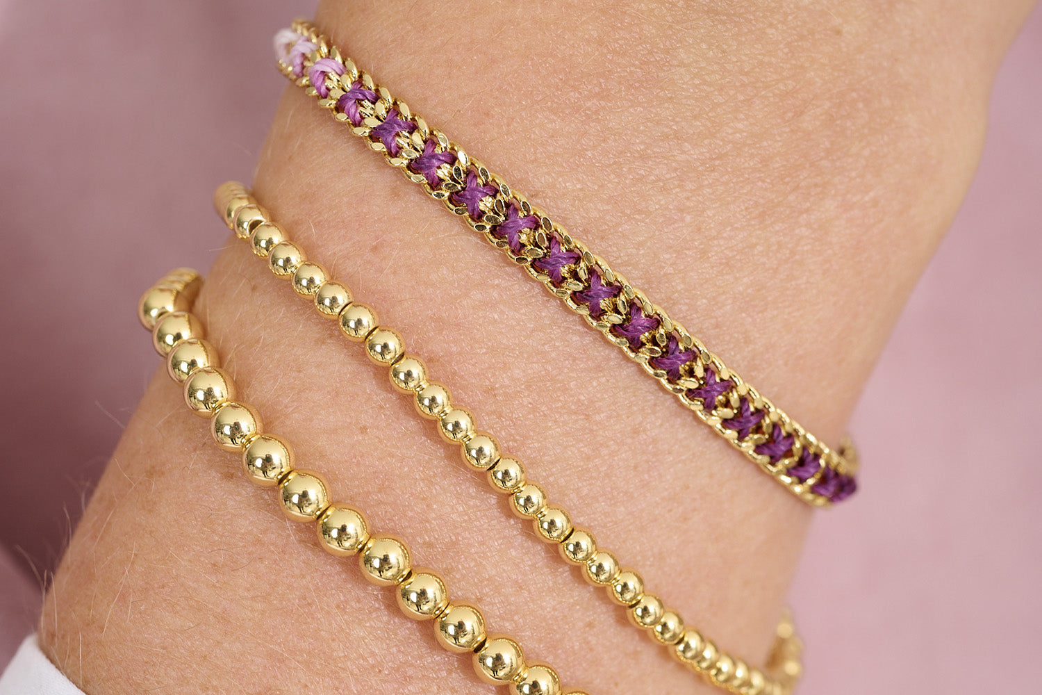 Jeju Purple & Gold Bracelet Stack styled on wrist with soft tailoring and layered gold jewellery for a radiant, feminine look.
