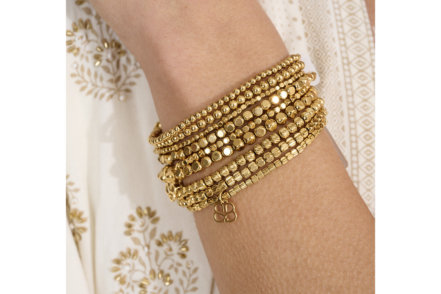 Kamala Minor Gold Stretch Bead Bracelet Set styled with other tonal gold jewellery, highlighting its delicate beadwork and effortless stacking versatility.