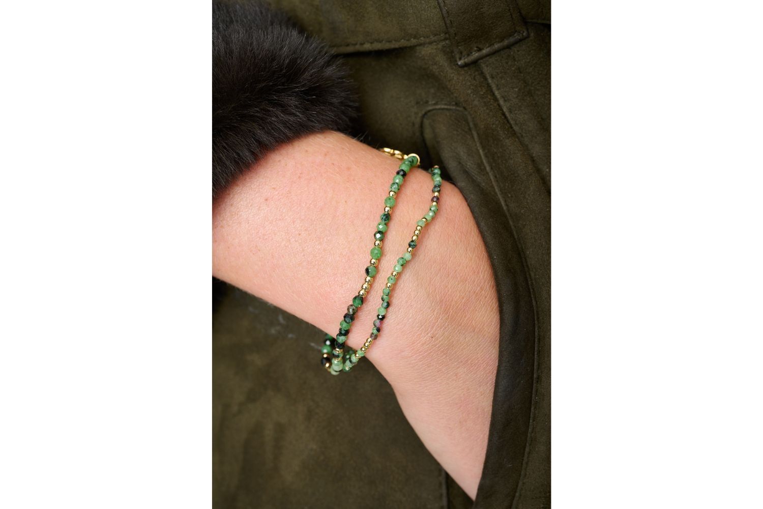 The Lilias Ruby Zoisite Bracelet styled in a colourful wrist stack with green, pink, and gold gemstone beads and filigree charm.