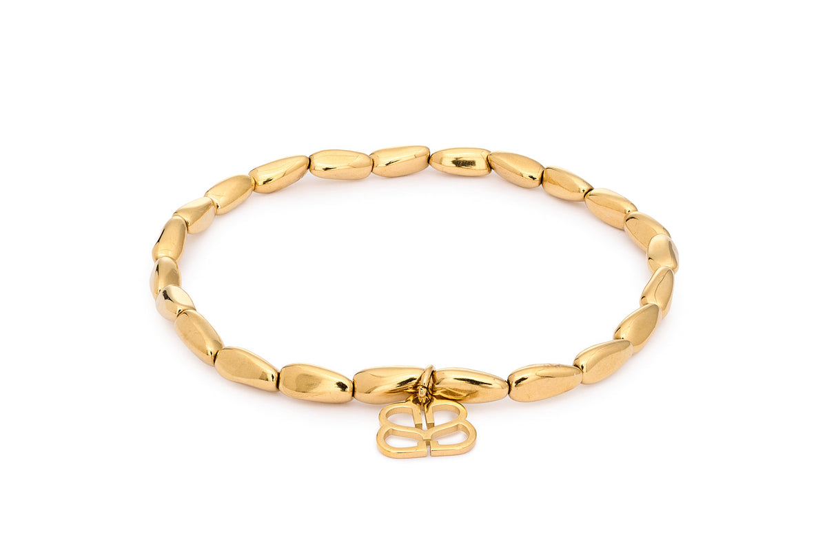 Liora Gold Bead Stretch Bracelet featuring smooth elongated 14k PVD gold-plated stainless steel beads with Boho Betty filigree charm in an 18cm stretch-fit design.