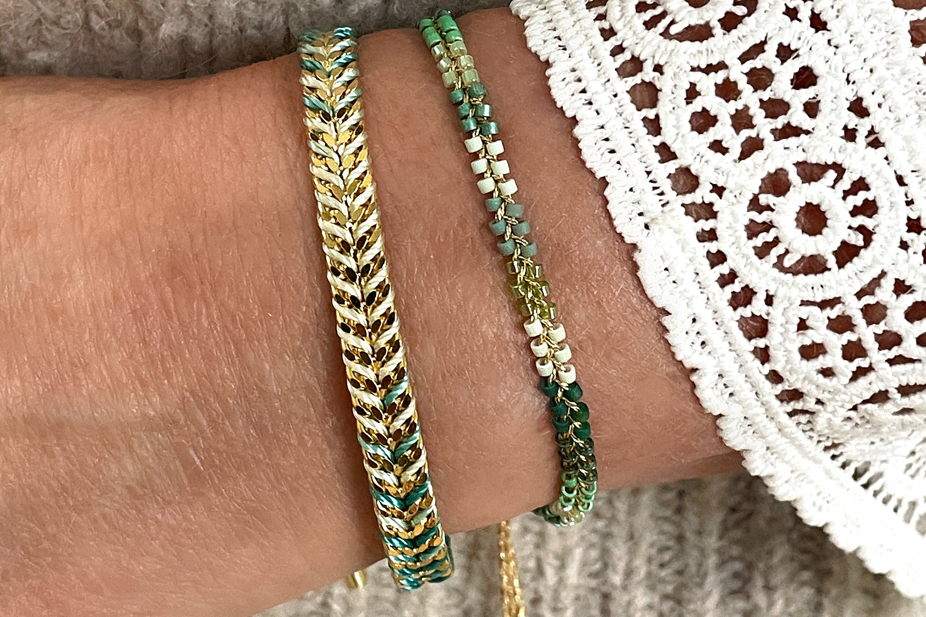 Marina Aqua Gold Braided Bracelet styled on the wrist, showcasing aqua and green Miyuki beads with gold accents, perfect for coastal-inspired fashion and summer getaways.