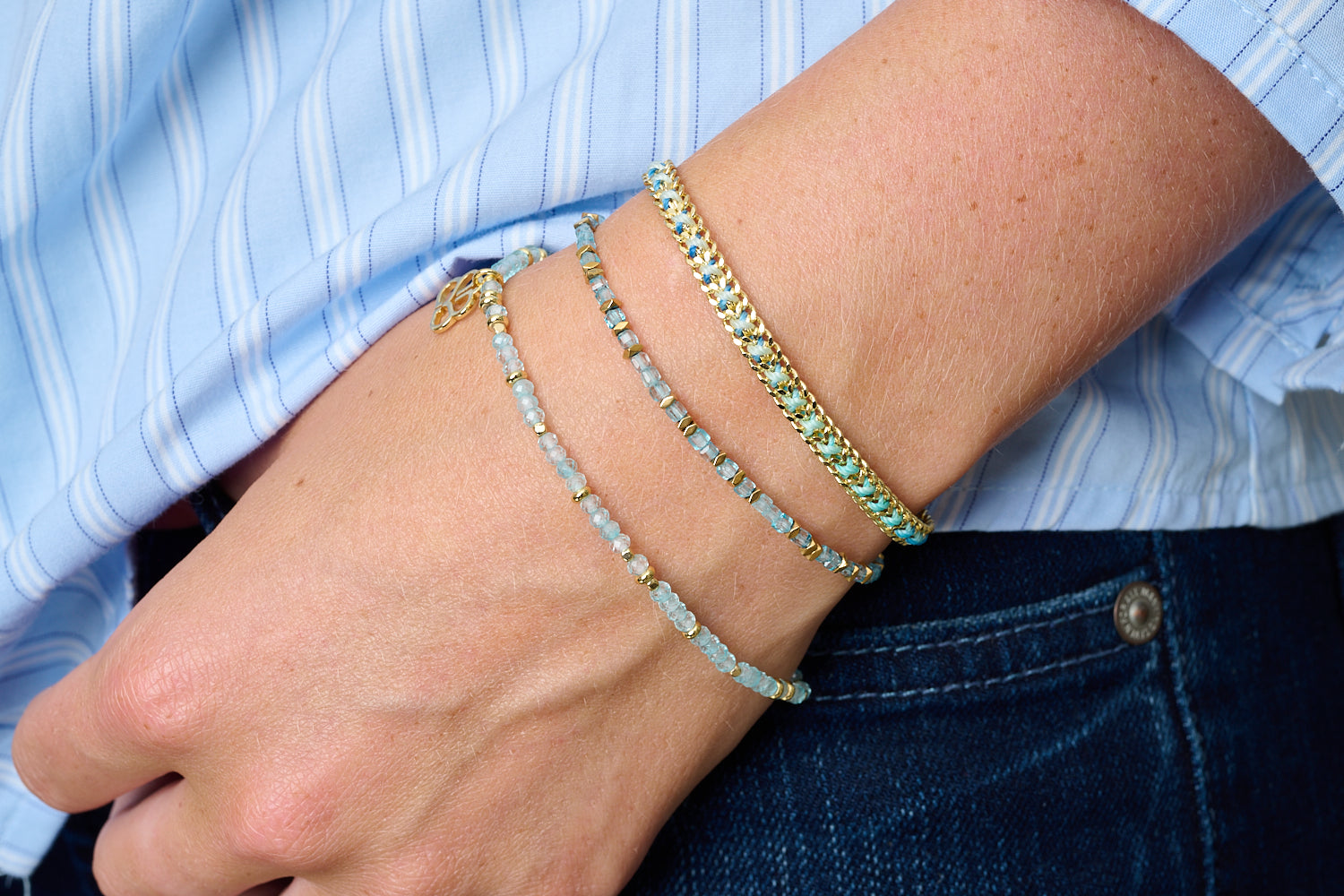 Montosa bracelet trio styled with denim—ocean blue topaz and warm gold for a cool, serene day-to-night glow.
