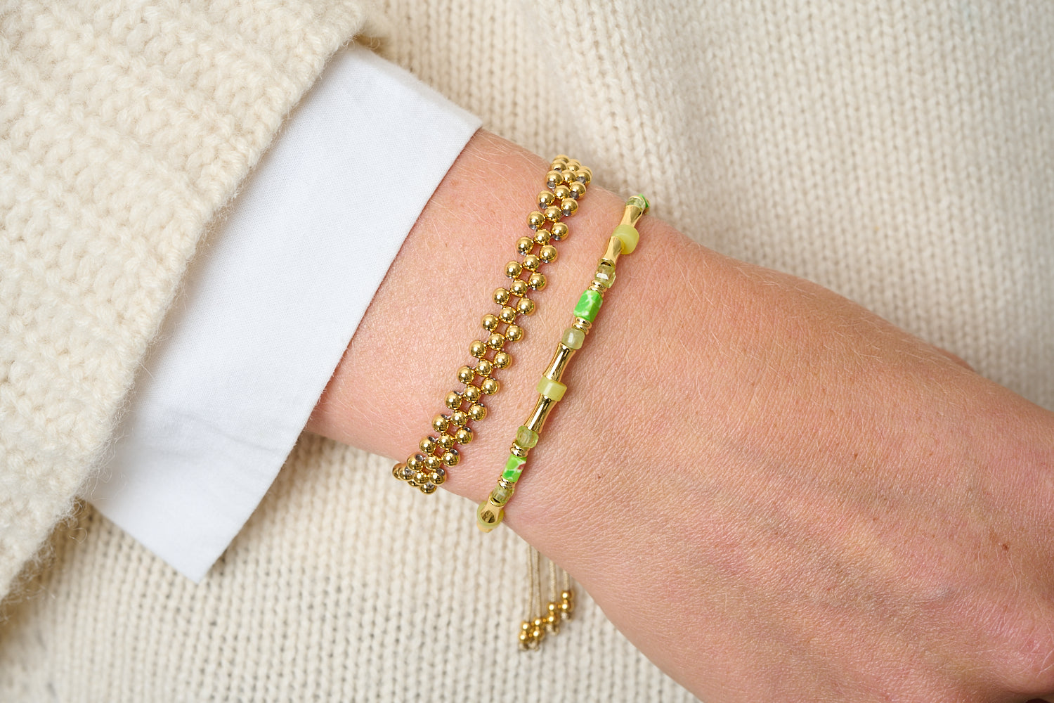 Rosario Peridot Gold Bracelet Stack worn with a cosy knit, gold beads and fresh green gemstones creating a bright, layered everyday bracelet look.
