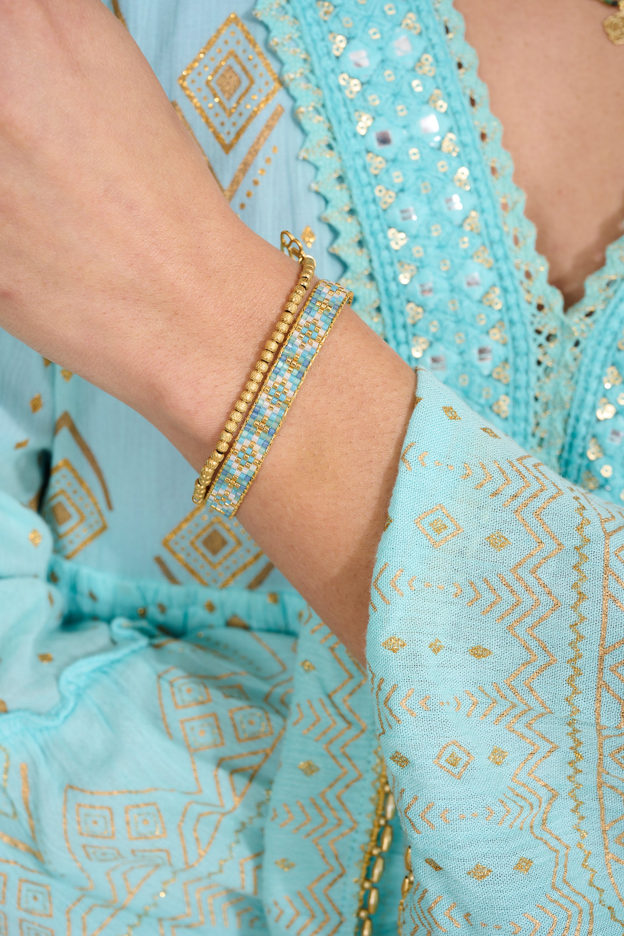 Saskia Aqua Gold Friendship Bracelet styled on the wrist, showcasing a festival-ready blend of blue, aqua, and gold beads, perfect for layering or wearing solo.