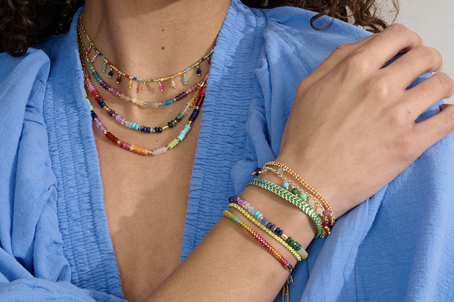 Skye Gold & Rainbow Gemstone Necklace styled on the neckline, showcasing vibrant natural stones and gold-plated accents—perfect for layering or wearing solo.