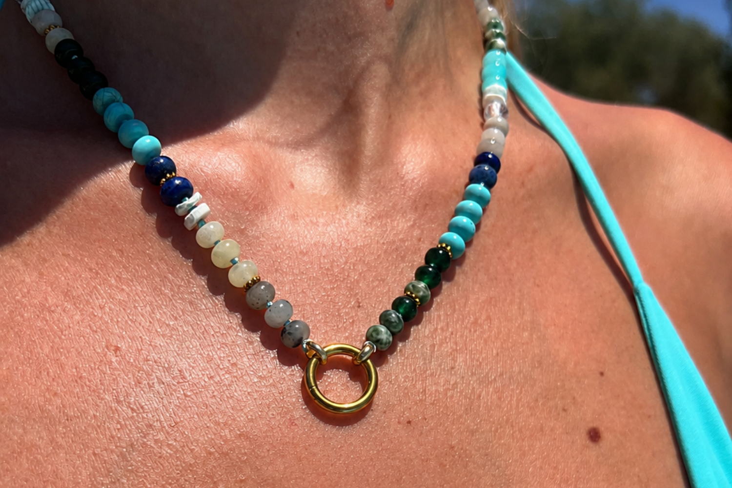 Amala Blue Bead Gold Charm Carrier Necklace worn layered, showcasing jade, shell, turquoise and labradorite beads with a waterproof 14k Gold PVD charm carrier clasp.