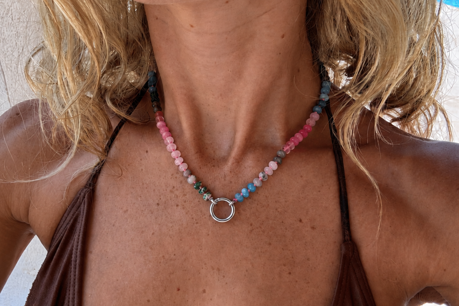 Model wearing the Amala Pink & Blue Silver Charm Carrier Necklace featuring colourful jade, rose quartz and labradorite gemstone beads with a waterproof white gold plated stainless steel charm carrier clasp.