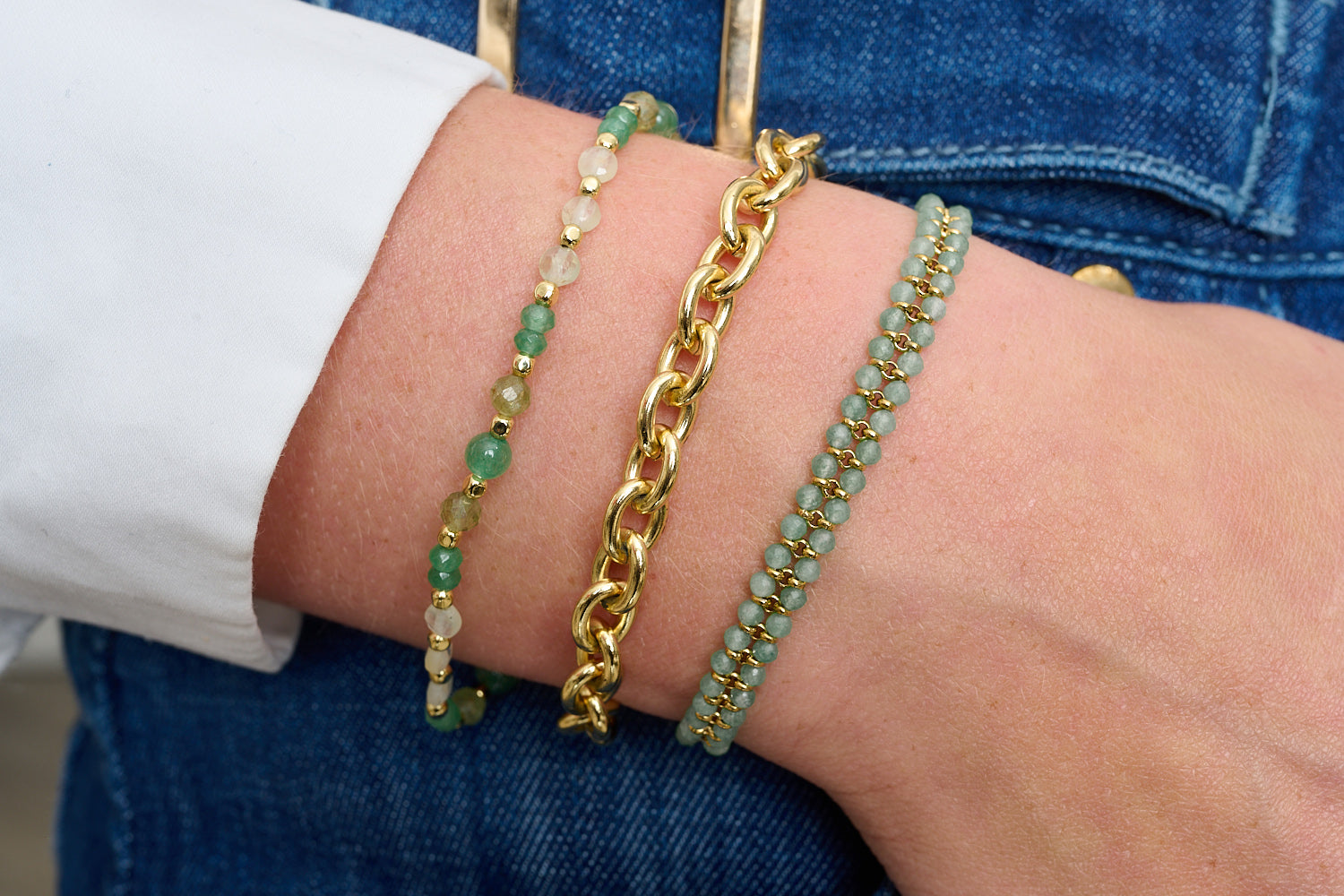 Cabruna stack styled with denim, fresh green gemstones and glowing gold for effortless polish.