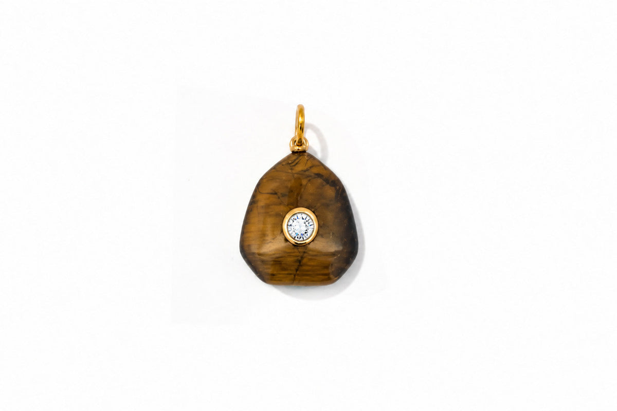 Kalis tiger’s eye gemstone charm in gold with a clear crystal centre, the detachable pendant on this necklace.