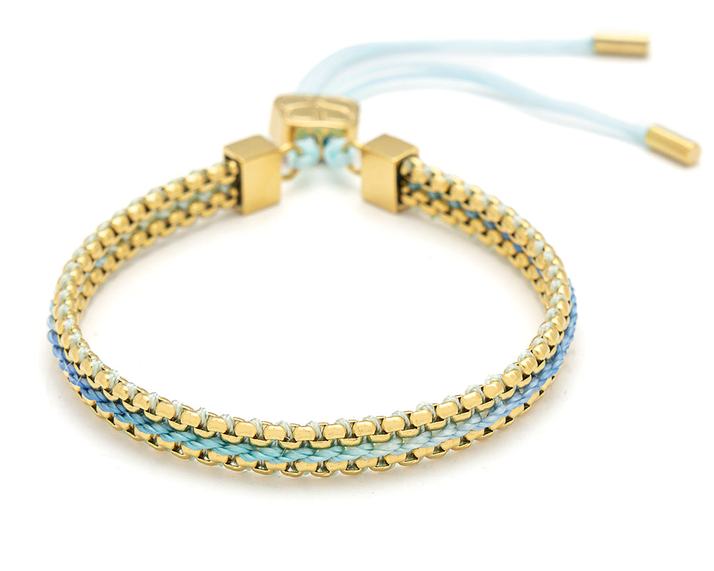 Bloom sky blue braided friendship bracelet with soft blue threads and gold chain detailing with adjustable slider fastening.