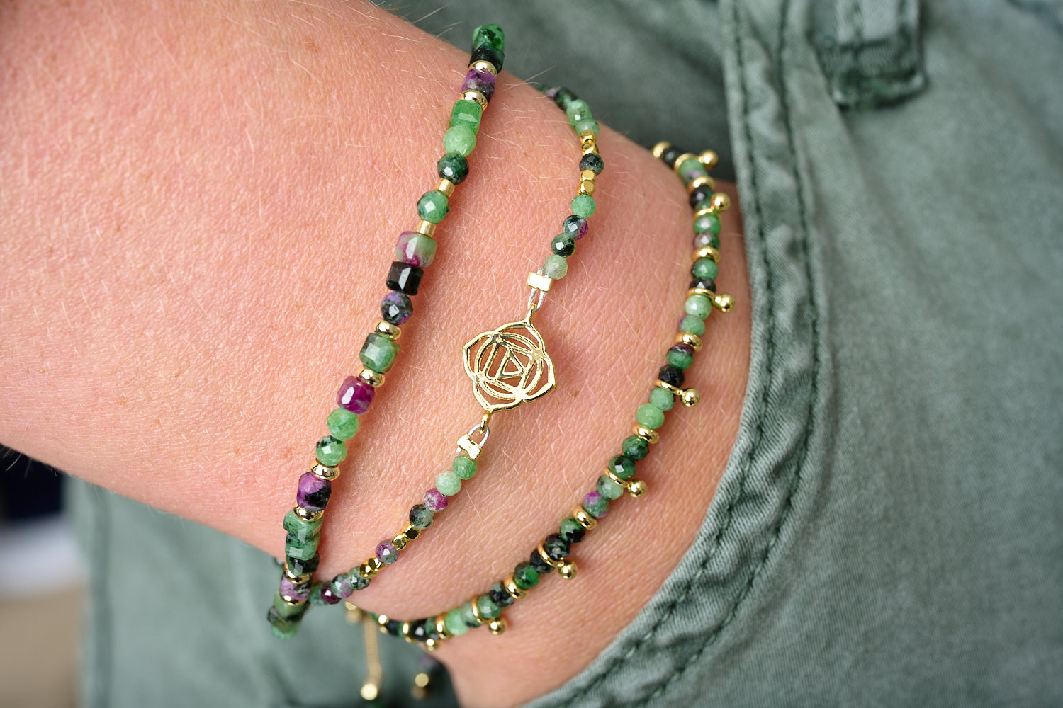 Coiba Ruby Zoisite Bracelet Stack styled on wrist, showing cube-cut beads, Root Chakra charm and fine slider in polished gold accents