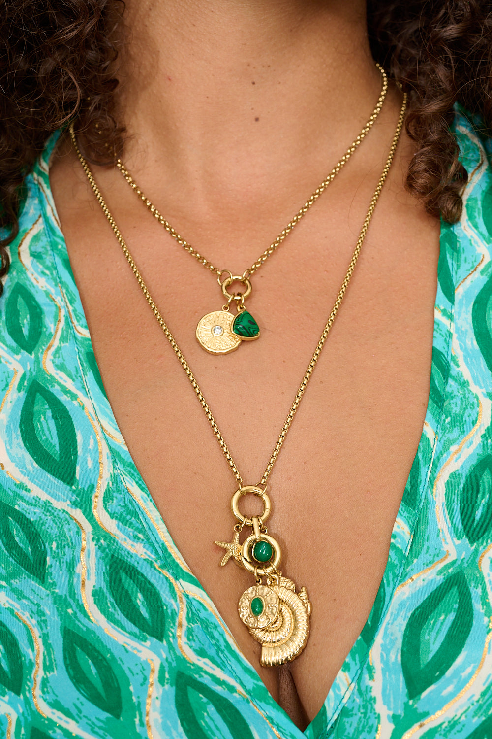 Eira gold pendant necklace styled with boho layers and soft summer tones.