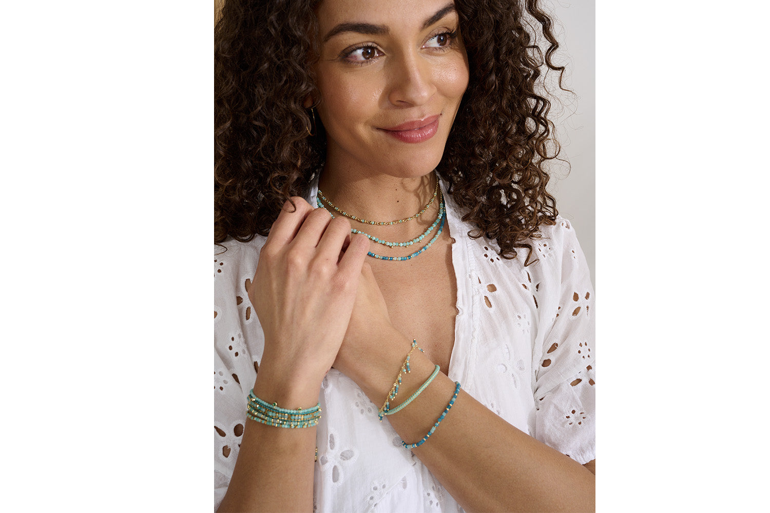 Emelia Turquoise & Gold Braided Bracelet styled on the wrist, layered with other gold pieces for a beachy boho look.