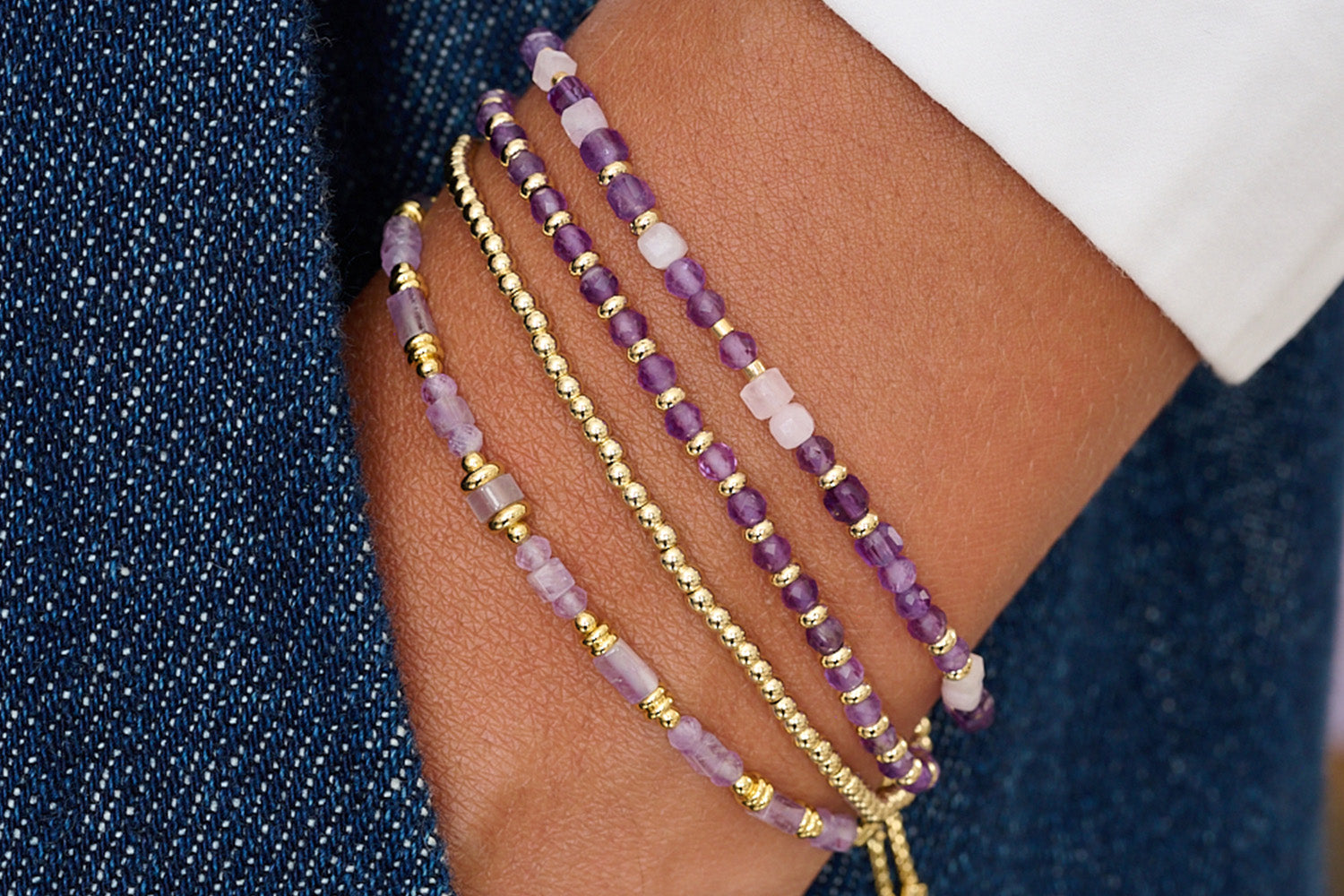 Hainan Amethyst & Gold Bracelet Stack styled on wrist with layered Boho Betty lilac gemstone and gold bracelets