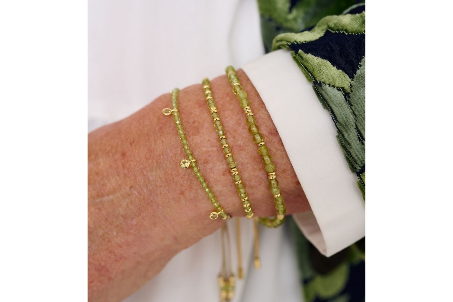 Holly Gold & Peridot Beaded Slider Bracelet styled on the wrist, featuring Peridot beads, gold accents, and CZ charms, perfect for a playful summer look.