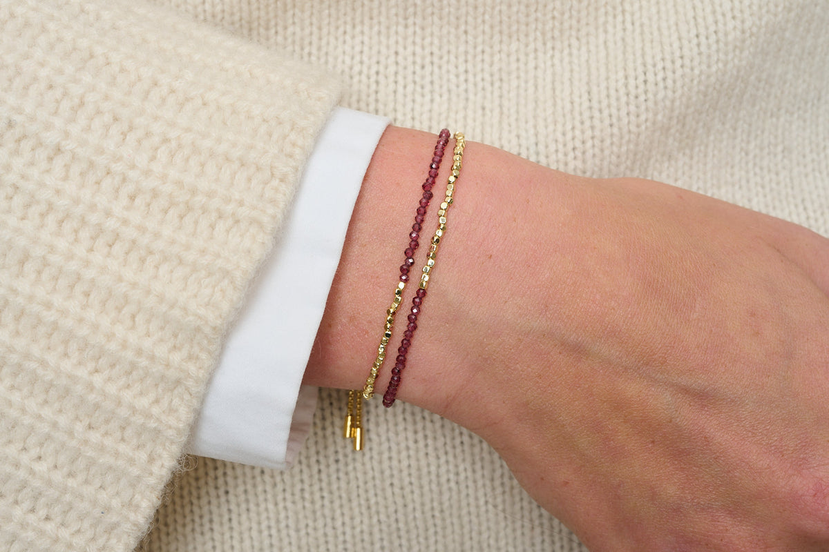 Juniper Garnet & Gold Double Strand Bracelet featured on wrist with other stacking bracelets
