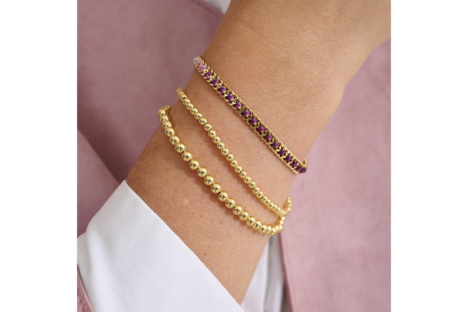 Lilia Gold & Purple Ombre Braided Bracelet styled on wrist, showcasing ombre purple threads and shimmering gold chain.