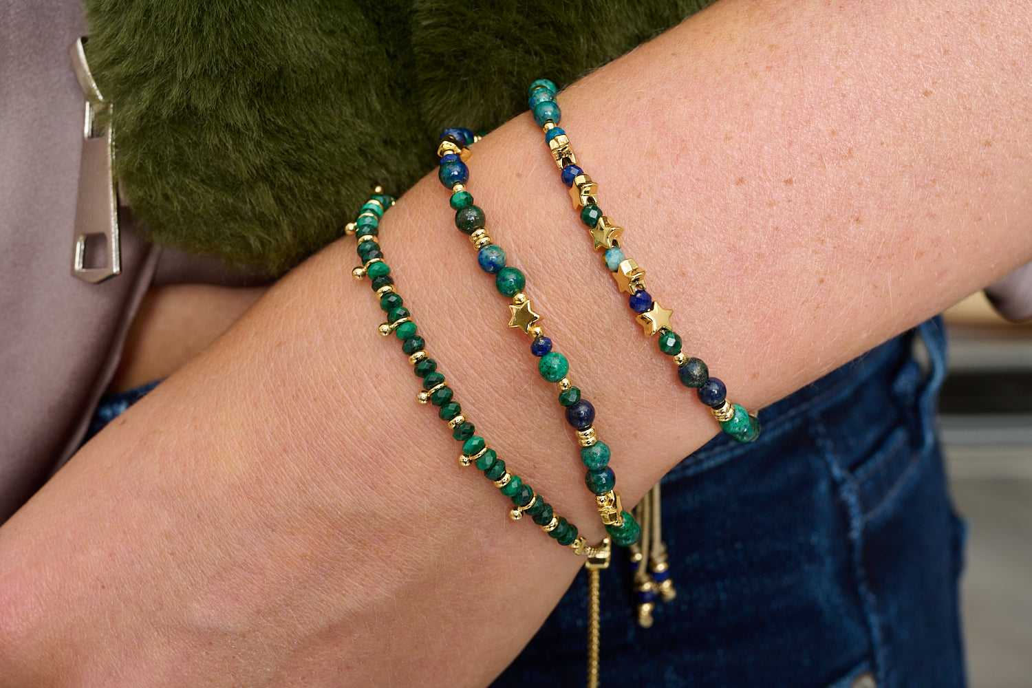 Mamey azurite and gold stacking bracelets styled on wrist, celestial blues and greens with golden shimmer and star charms.