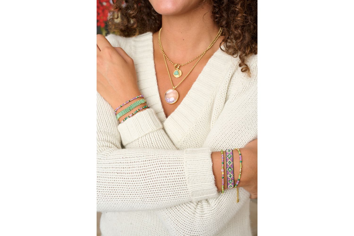 Meli gold, green and purple stretch bead bracelet styled in Boho Betty bracelet stack with model wearing layered necklaces