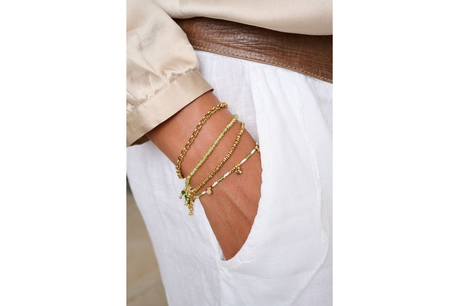 Rania White Green & Gold Friendship Bracelet styled with a golden stack and natural textures, perfect for summer days and barefoot moments.