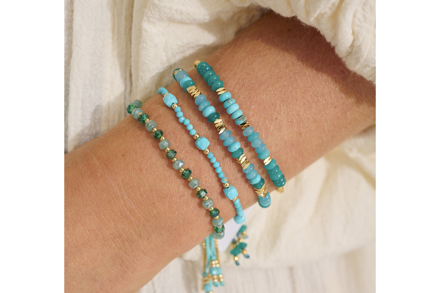 Serena Gold, Turquoise Howlite & Jade Gemstone Bracelet stacked with other boho bracelets, showcasing its vibrant ocean tones and gold accents.
