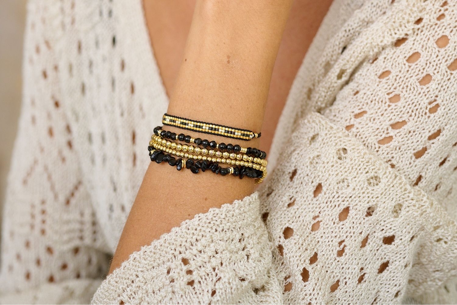 Starshine Black Beaded 3 Rows Friendship Bracelet styled on the wrist, featuring black beads and gold accents, perfect for layering or wearing solo.