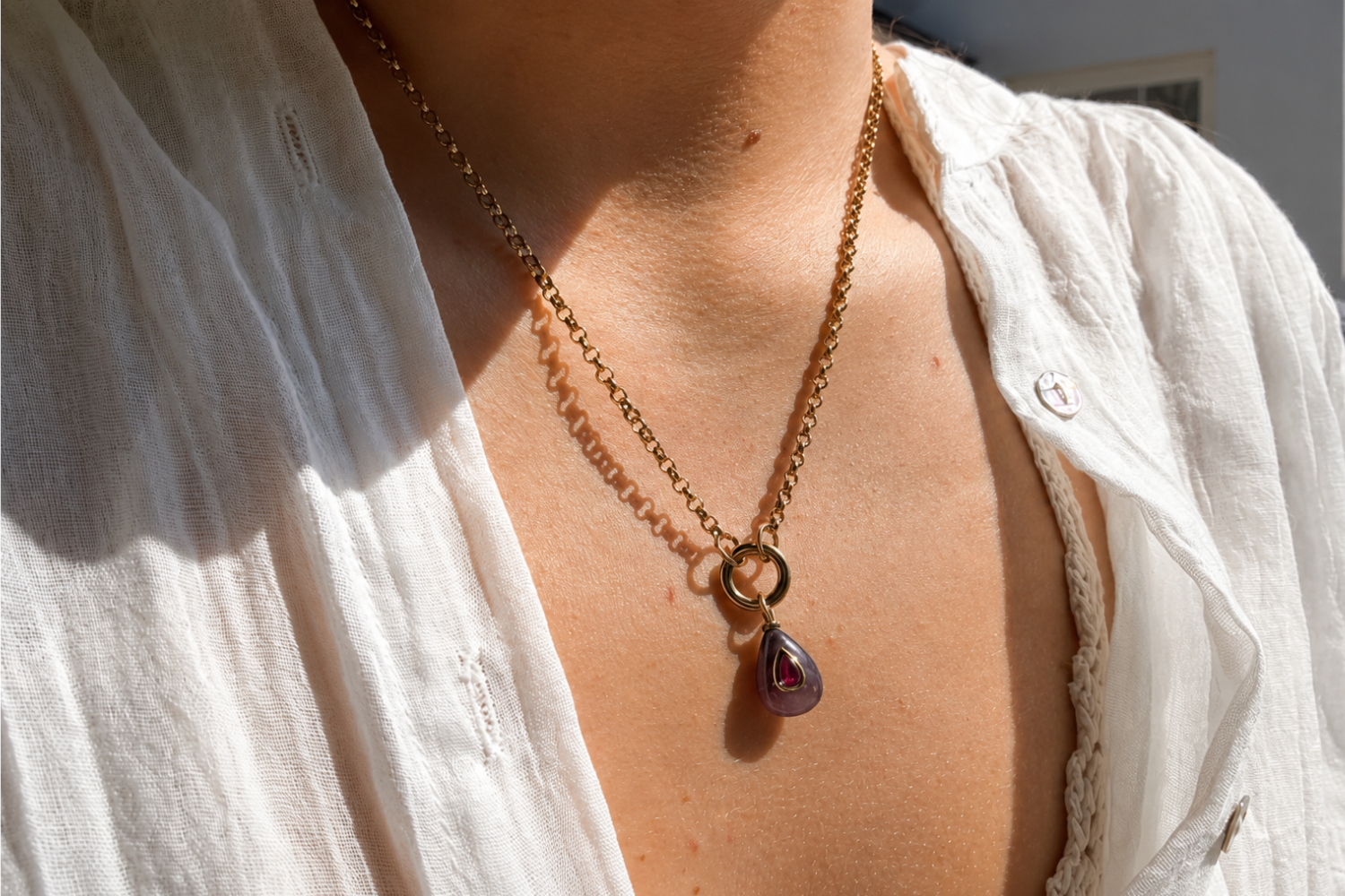 Thalia Short Amethyst Teardrop Pendant Necklace worn layered on the neckline with a natural amethyst pendant and waterproof 14k gold PVD chain.