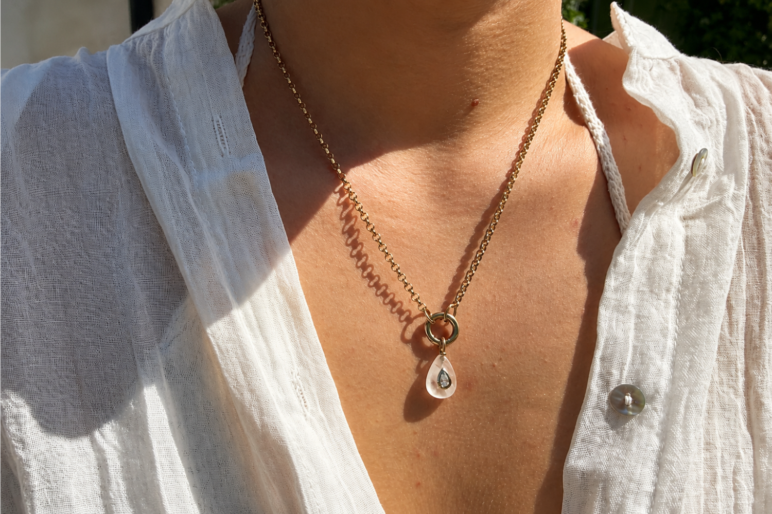 Thalia Short Clear Quartz Teardrop Pendant Necklace worn layered on the neckline with a clear quartz pendant and waterproof 14k gold PVD chain.