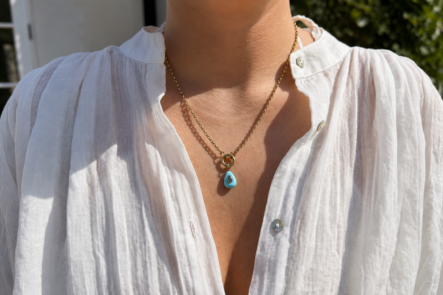 Thalia Short Turquoise Howlite Teardrop Pendant Necklace worn layered on the neckline with a turquoise howlite pendant and waterproof 14k gold PVD chain.