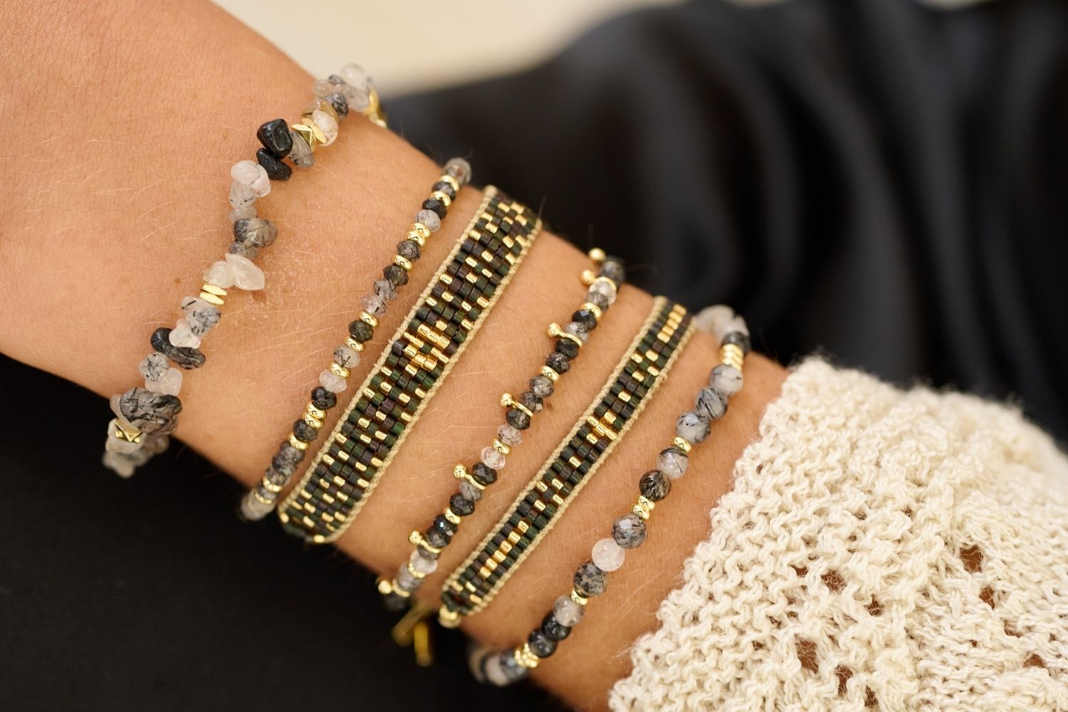 Wonder Gold & Black Rutilated Quartz Stretch Bead Bracelet styled on the wrist, showcasing shimmering quartz beads with cosmic inclusions and gold accents, perfect for adding a touch of boho luxe.